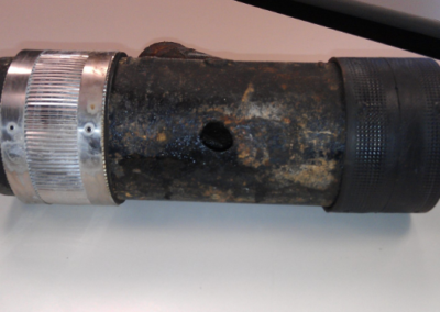 A hole in a cast iron fitting (caused by air). Repaired by Cinch Mechanical.