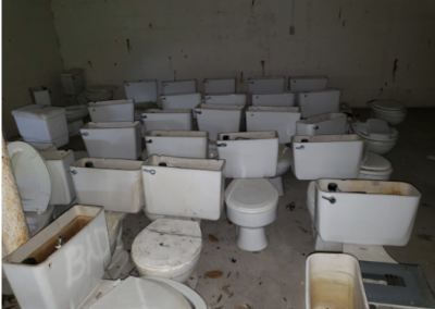 A room of discarded toilets after Cinch Mechanical replaced toilets at an apartment complex in Maryland.